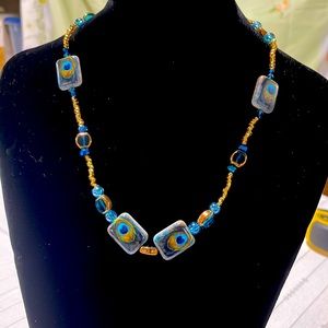 Handmade necklace with peacock feather design.